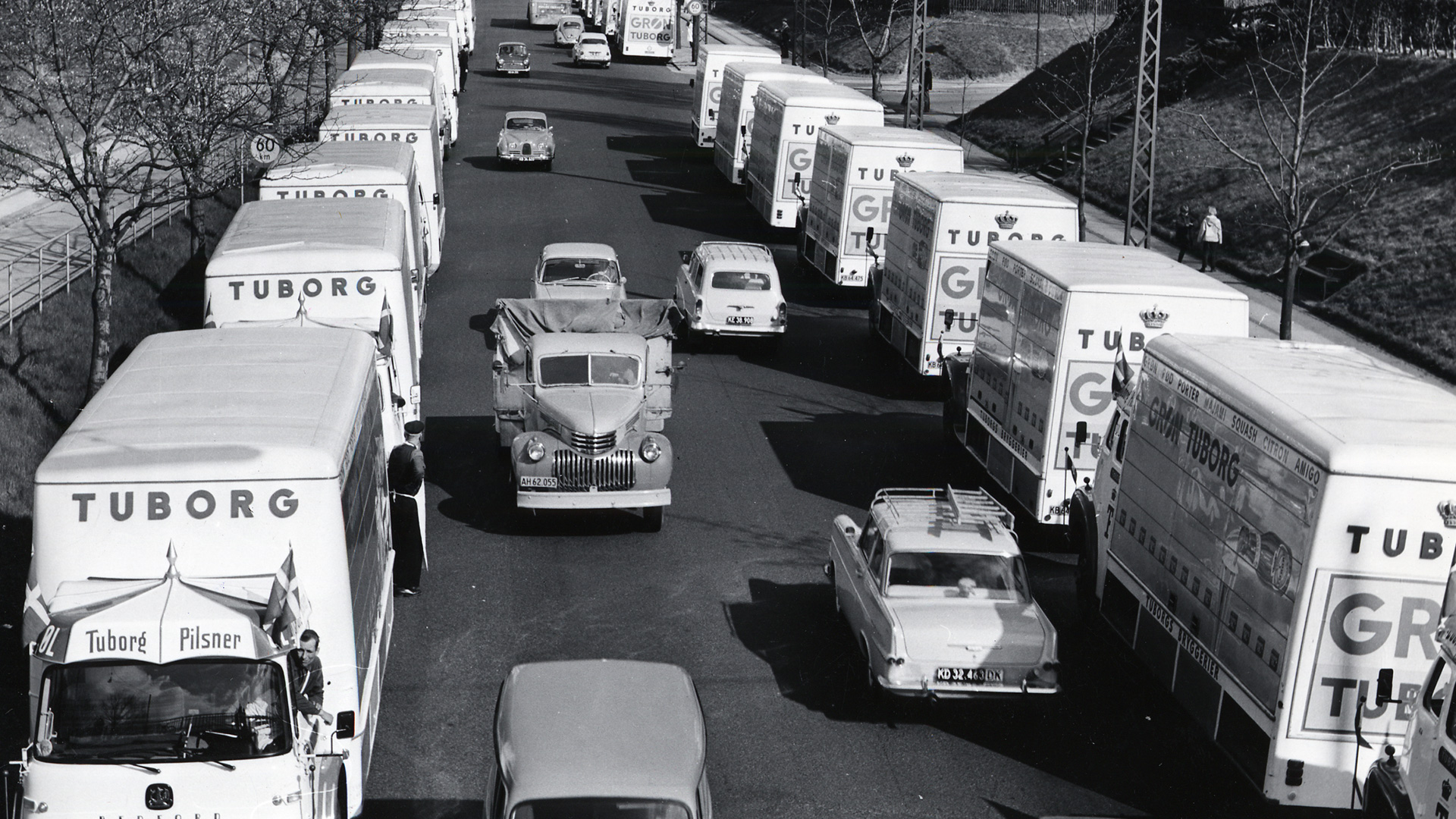 arhivska crno-bela fotografija kolone tuborg kamiona na ulici